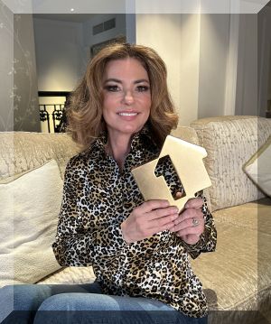 Shania Twain poses with her Official Number 1 Album Award from Official Charts Company for Queen of Me (credit: Official Charts Company)